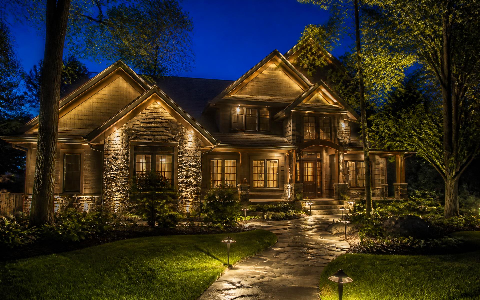 Craftsman home illuminated with warm landscape lighting at night